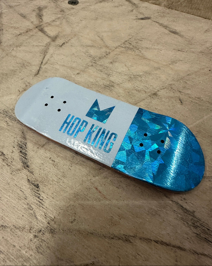 Skateboard deck with blue and white design on a textured surface