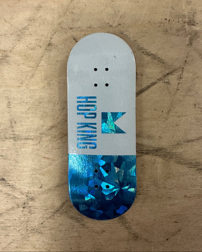 Skateboard deck with 'Hop King' logo on a textured surface